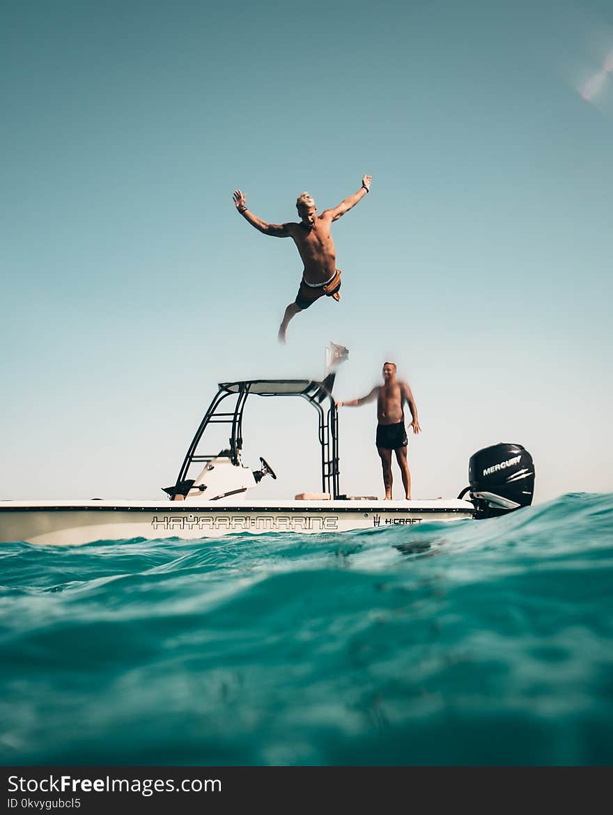 Photo of Man Jumping from Boat to the Sea