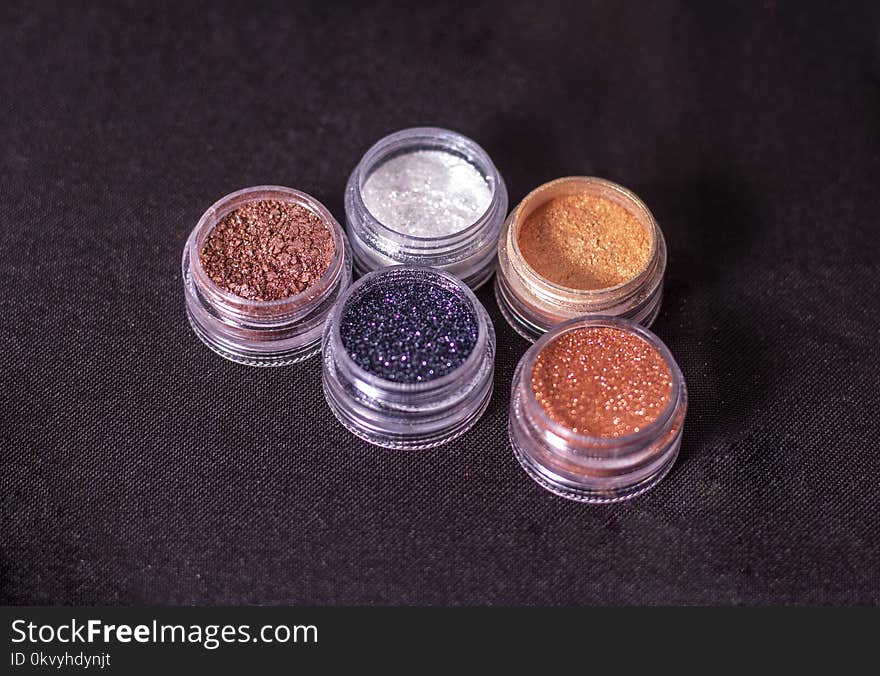 Close-Up Photo of Glitters on Round Containers