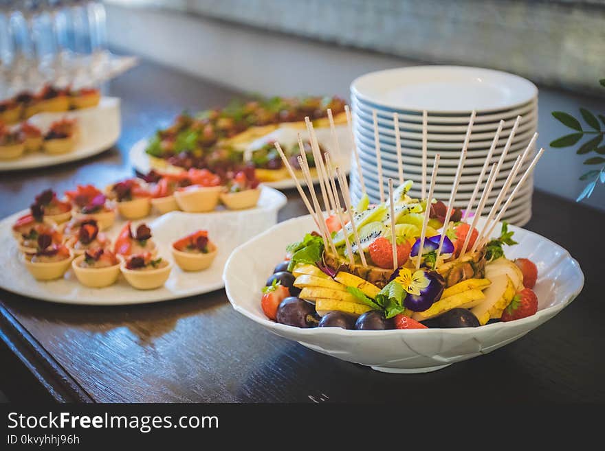 Fruit Salad in White Ceramic Bowl Near Plates