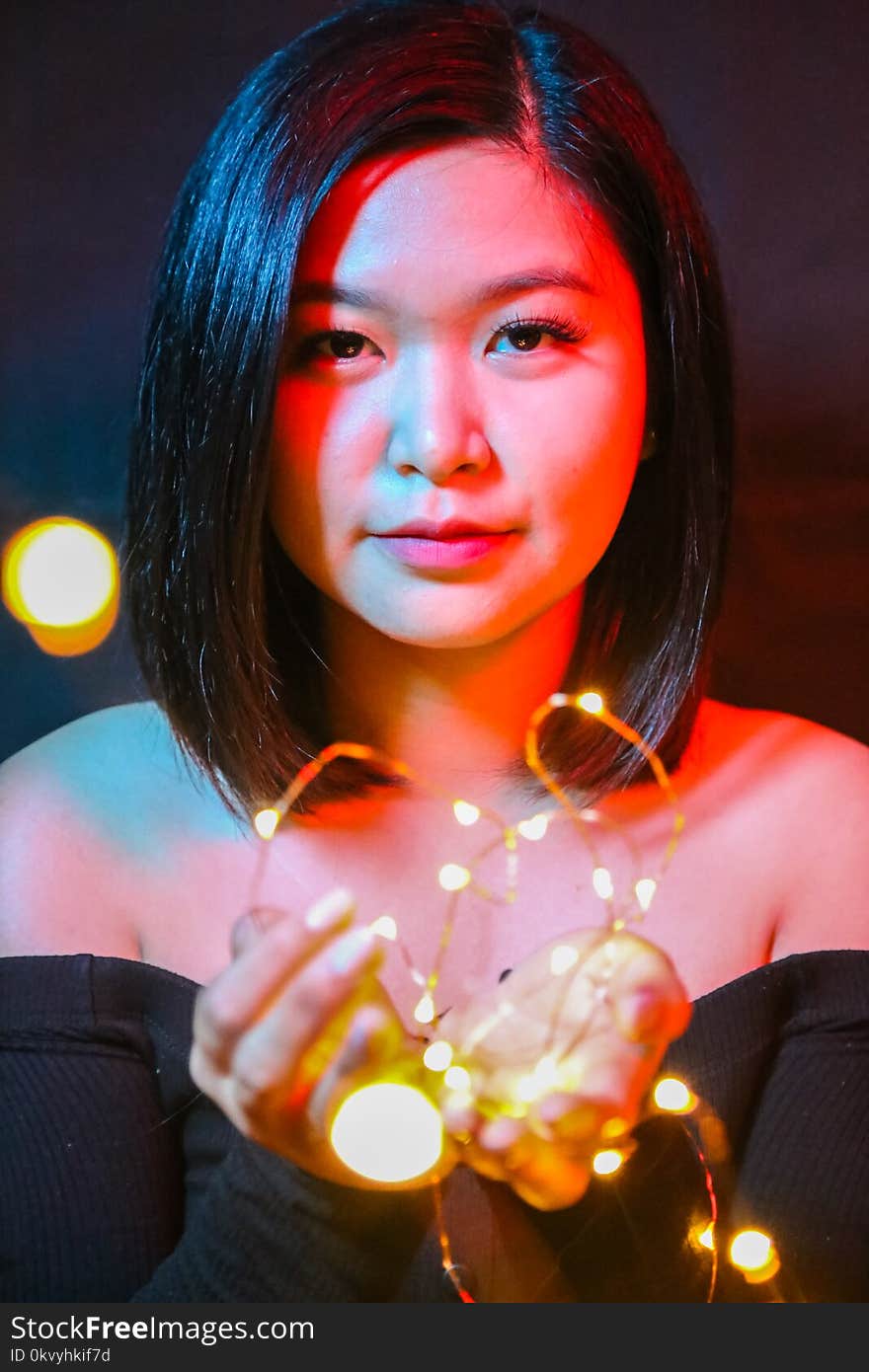 Woman Wearing Black Off-shoulder Top Holding String Lights