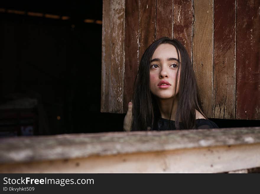 Selective Focus Photography of Woman in Front of Brown Wooden Wall