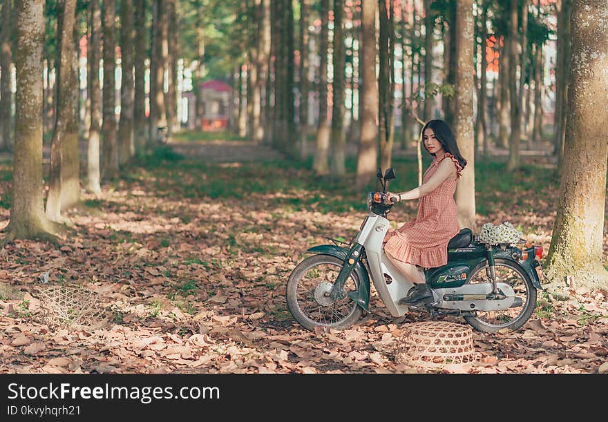 Woman Riding Underbone Motorcycle Between Trees