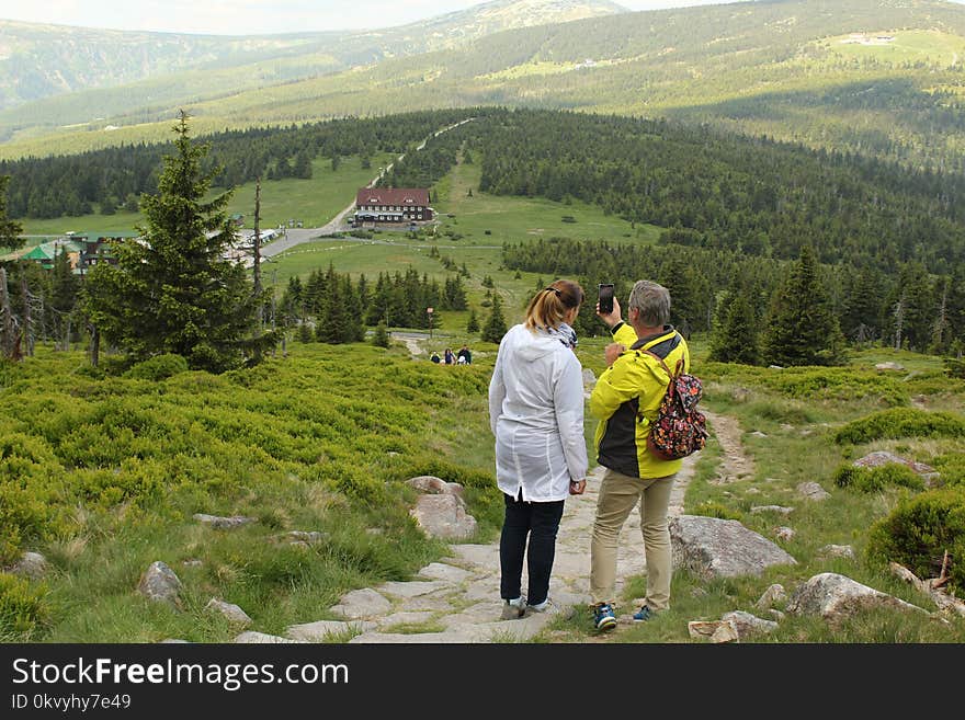 Woman Beside Man on Top of Mountain Taking Selfie