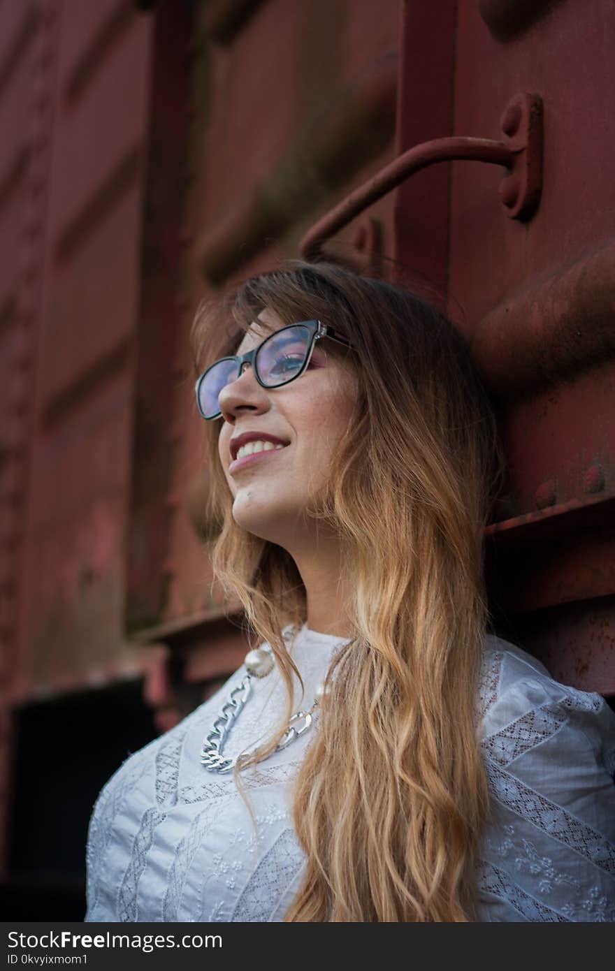 Woman in White Top Wearing Silver-colored Chain Necklace Leaning on Train