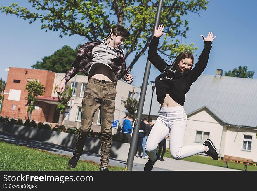 Woman in Black Sweatshirt and White Pants