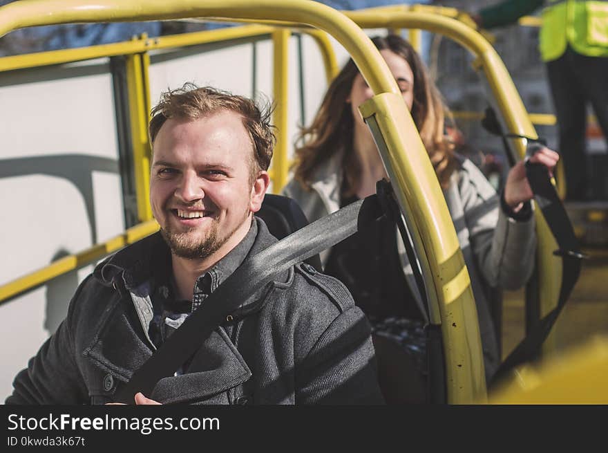 Man and Woman Riding on Yellow Framed Cart