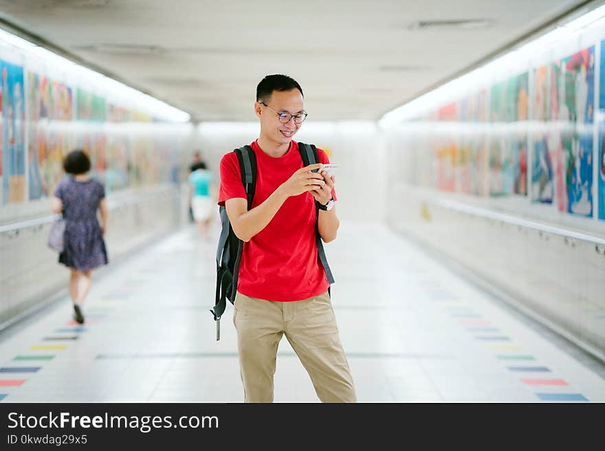 Man Wearing Red Crew-neck T-shirt and Brown Pants Photo