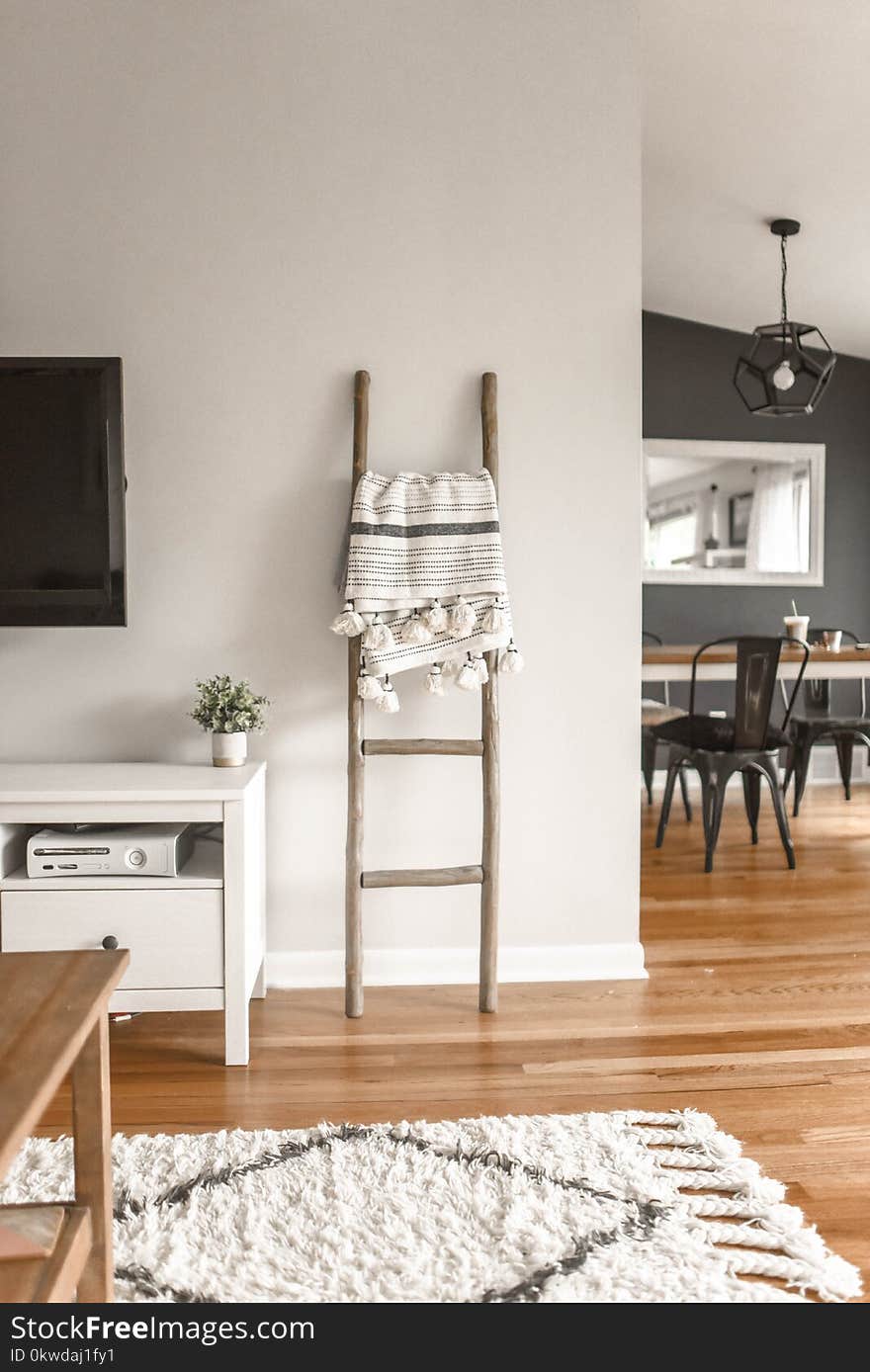 Gray Wooden Ladder on White Painted Wall