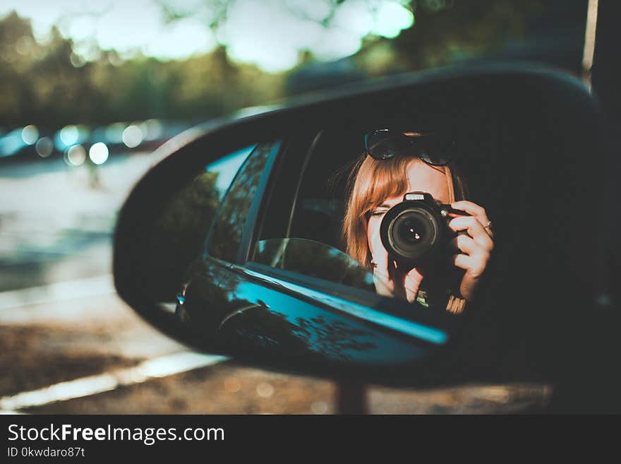 Selective Focus Photography of Woman Taking Camera Through Mirror