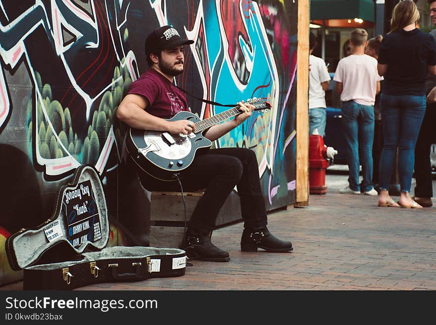 Man Playing Black Cutaway Guitar