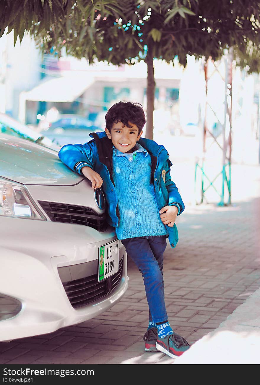 Photo of a Boy Leaning on Car