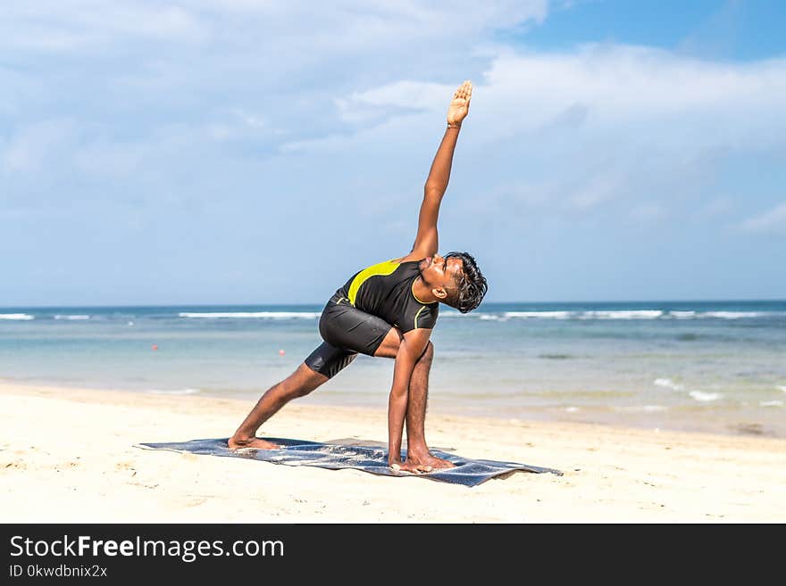 Man Doing Yoga Pose on Blue Mat Beside Seashore