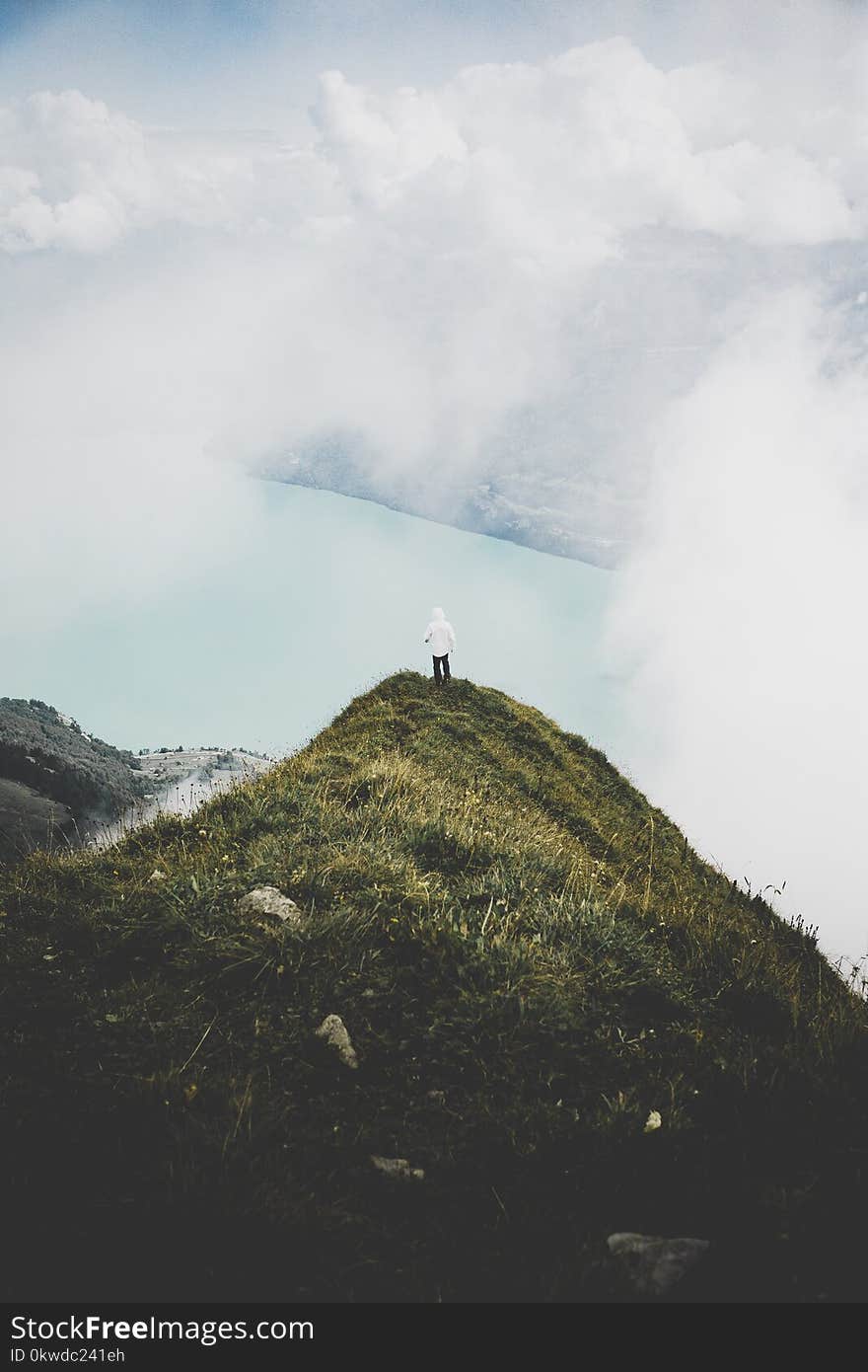 Person Standing on Green Grass Mountain