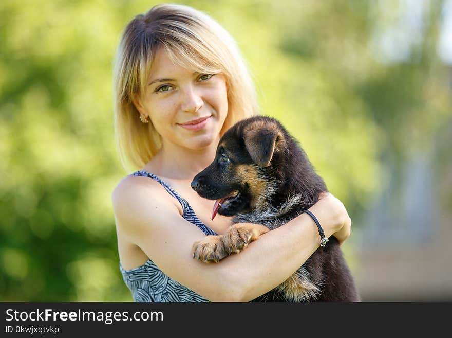 Young smiling woman with puppy of german shepherd