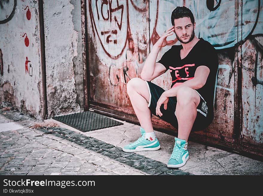 Man In Black T-shirt And Shorts Leaning on Wall