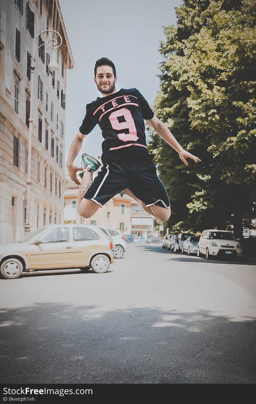 Photo of a Guy Jumping on Road