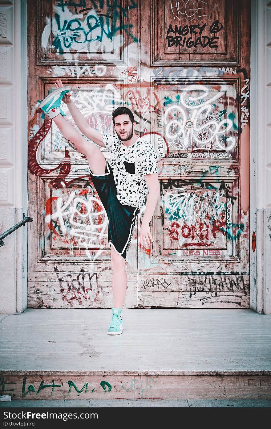 Man Wearing Black And White Crew-neck T-shirt With Foot Up