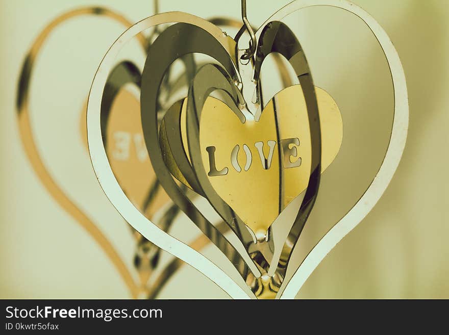 Shallow Focus Photography of Silver and Gold Heart Pendants