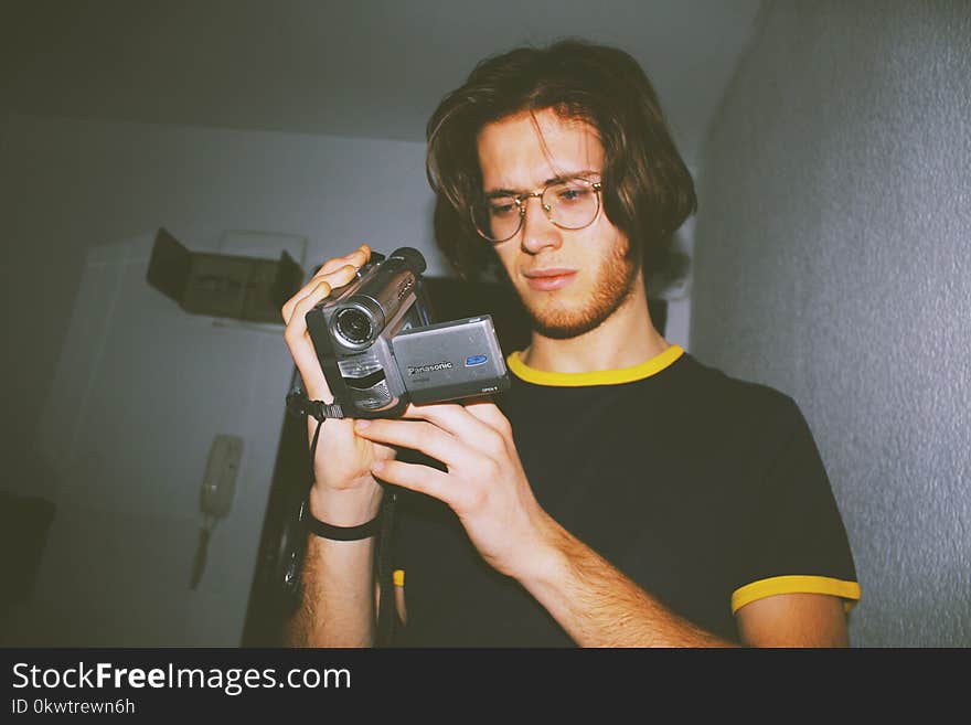 Man Wearing Black Shirt Holding Digital Camcorder