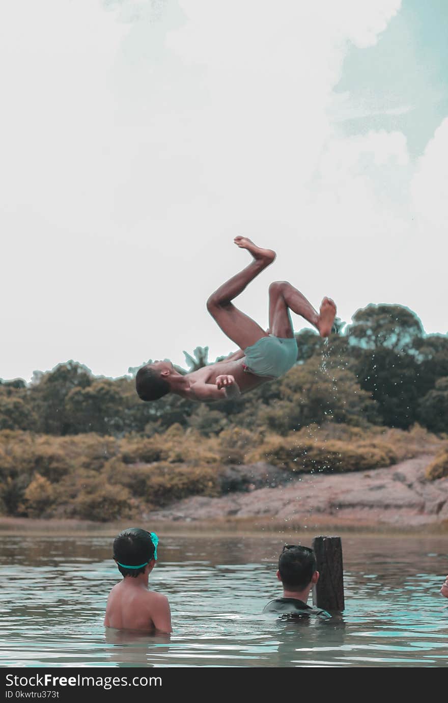 Person Wearing Shorts Back Flipped over Body of Water