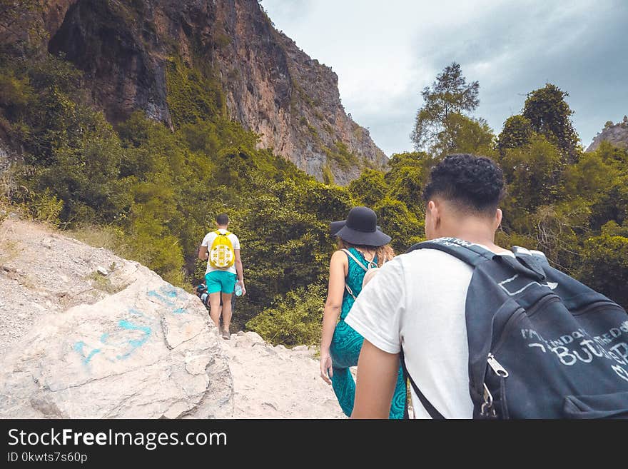 Man in White Shirt Carrying Black Backpack