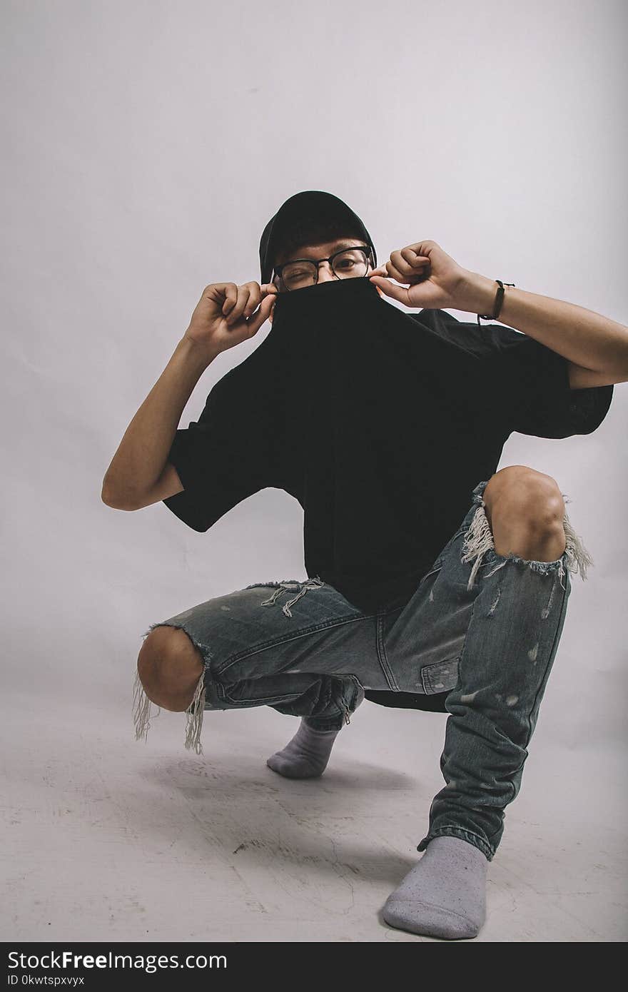 Man in Black Crew-neck Shirt and Blue Distressed Jeans Wearing Eyeglasses