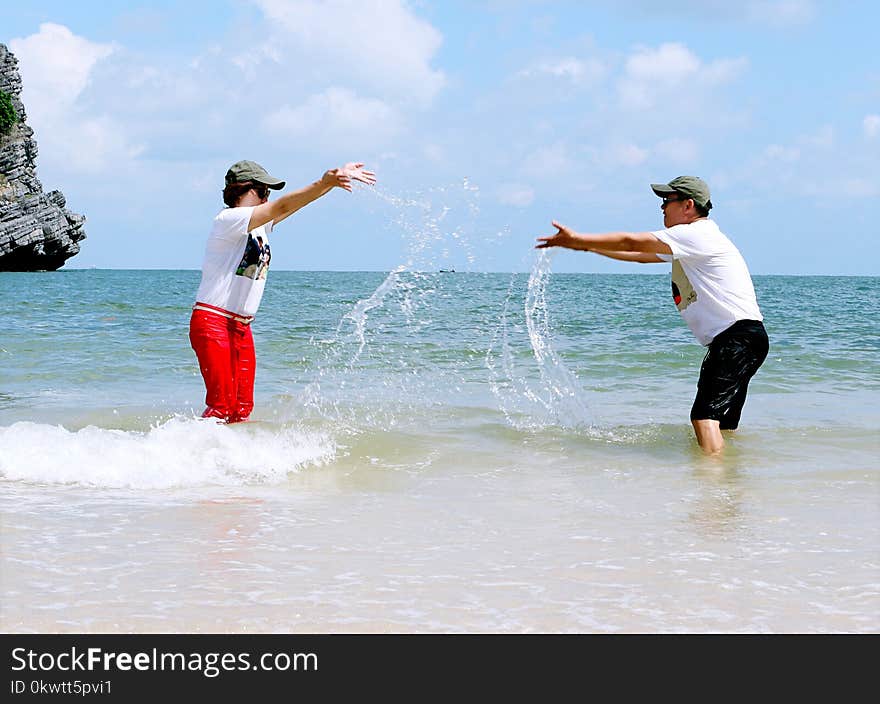 Man And Woman Splashing Water To Each Other