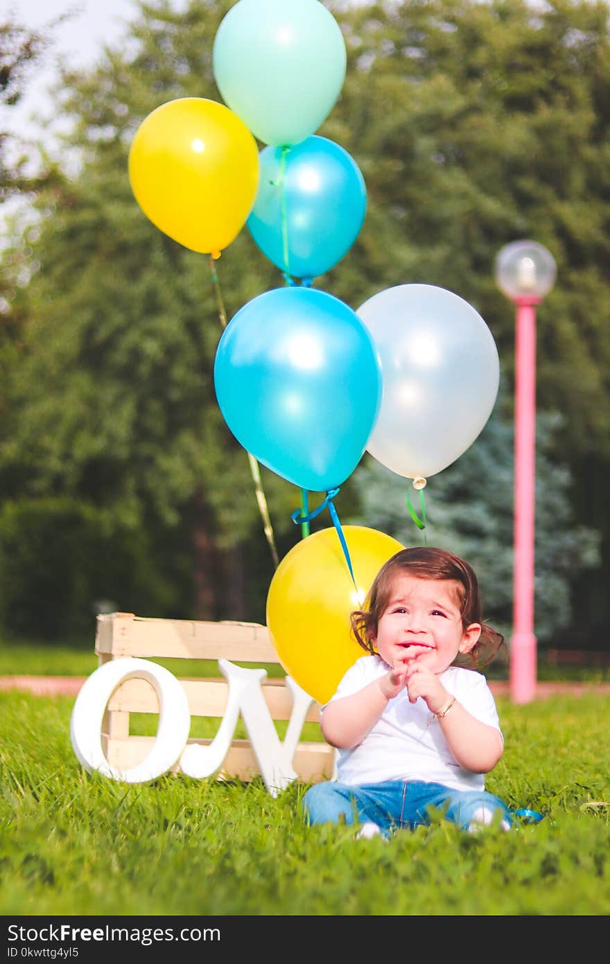 Girl Wearing White Shirt Near Teal, White, and Yellow Ballons