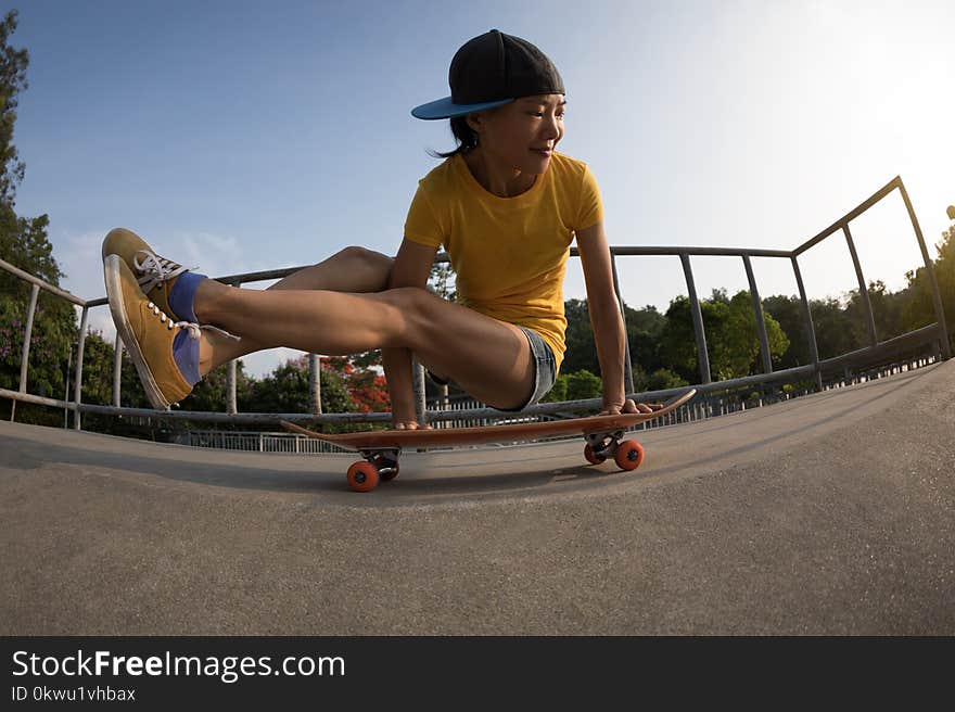 woman practicing yoga Bakasana Crane Pose on skateboard at skatepark ramp