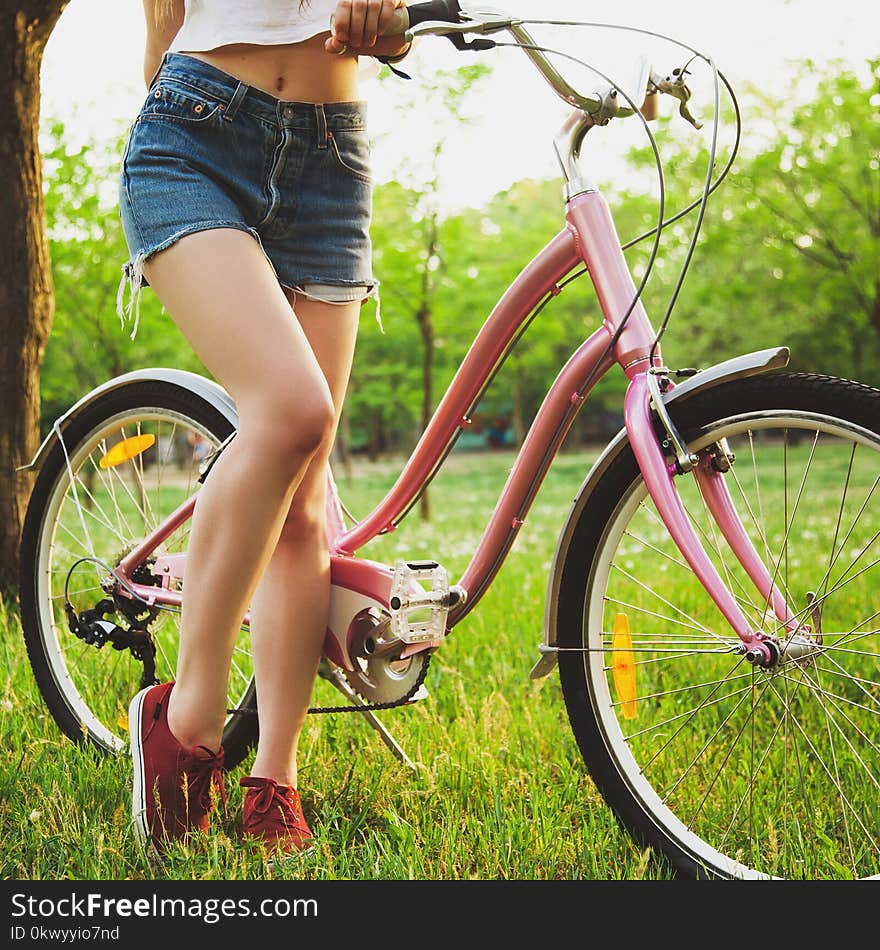 Beautiful woman with bicycle on the meadow in the park. Closeup picture. Beautiful woman with bicycle on the meadow in the park. Closeup picture