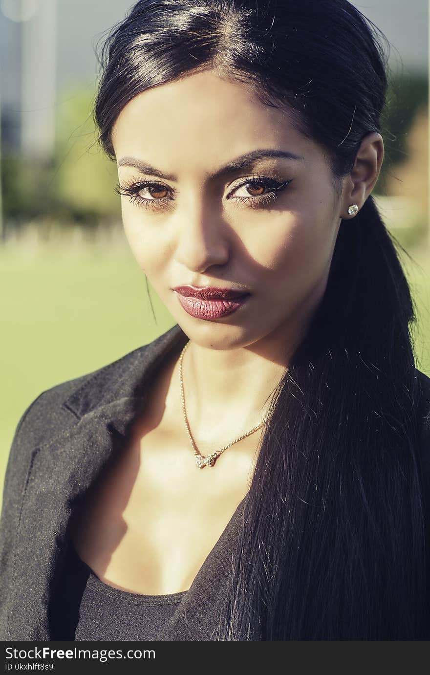 Well dressed elegant woman in business attire clothing talking on cell phone with long dark hair. Well dressed elegant woman in business attire clothing talking on cell phone with long dark hair