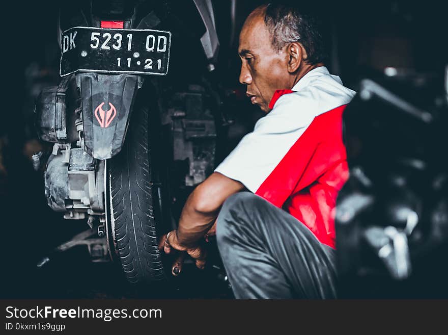 Selective Focus Photo of Man Looking on Motorcycle