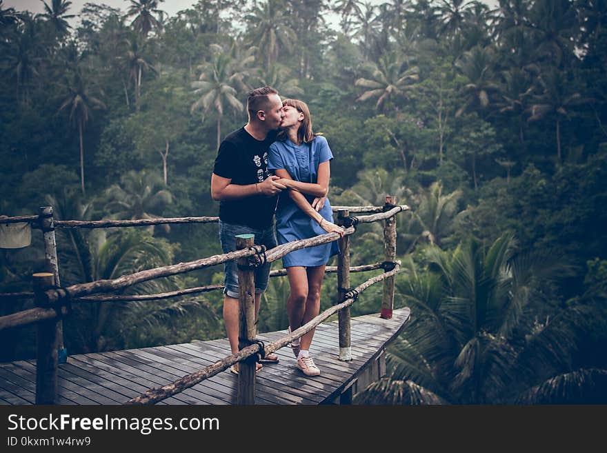 Man Kissing Woman on Cliff