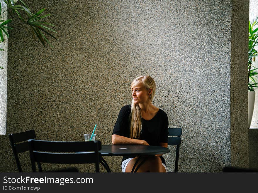 Woman in Black Scoop-neck Top Sitting on Black Metal Chair