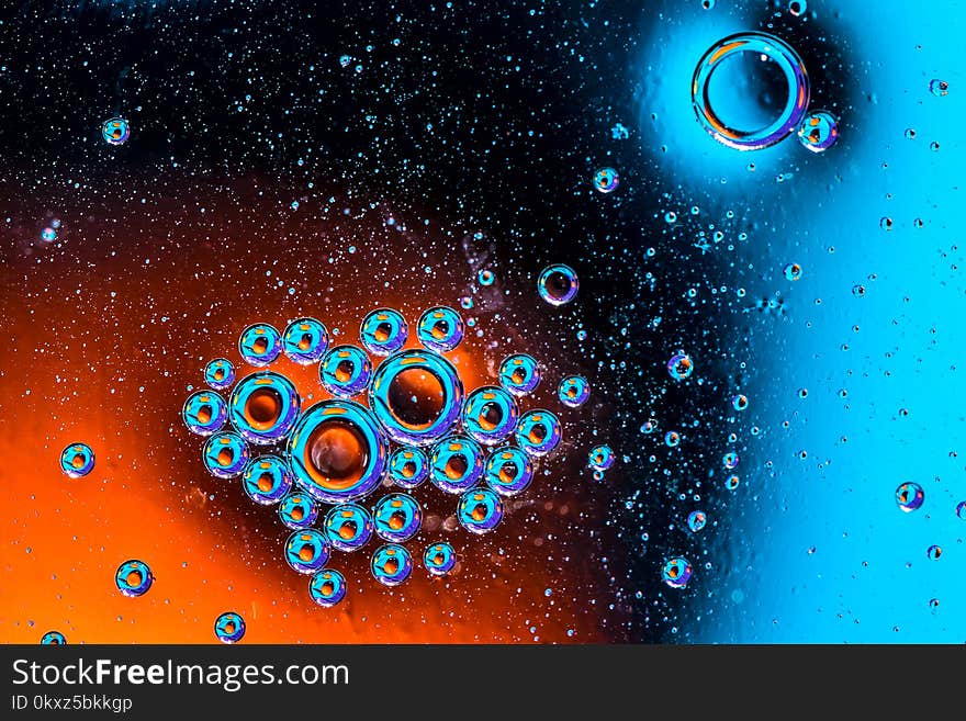 Macro shot of oil bubbles with water on colorful background. Space and universe planets styled abstract image