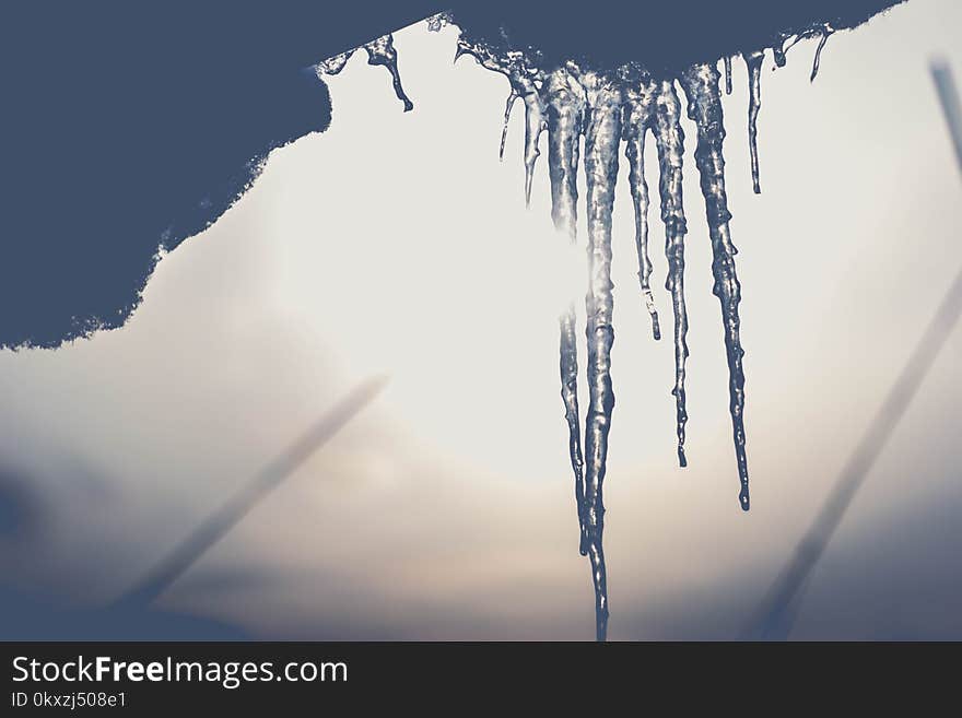 Long icicles in the spring sun. Yesterday, no one believed that it would be warm, and today these icicles tell us that spring will soon come.