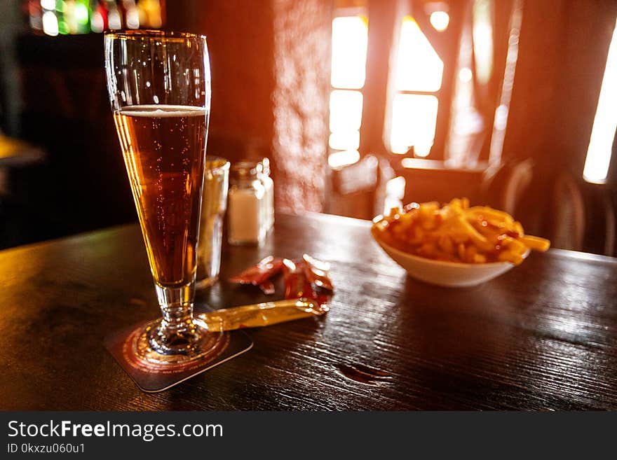 Cold Beer In A Glass On A Wooden Table In The Pub