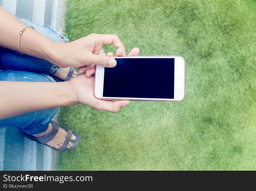 Girl,woman Looking At The Smartphone Sitting In Park