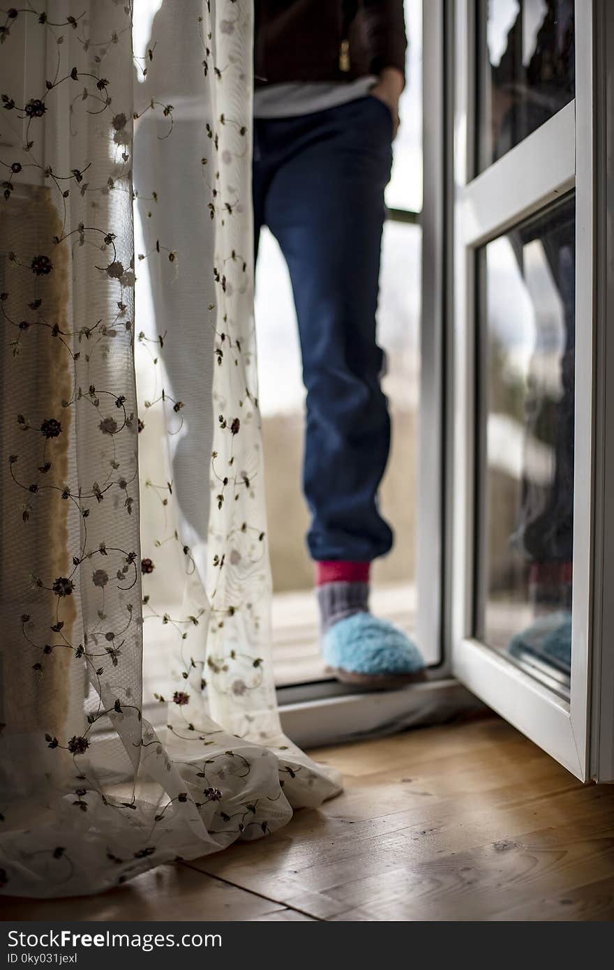 An open door PVC with access to the balcony, next to a beautiful tulle, in the background a man enters into the house. An open door PVC with access to the balcony, next to a beautiful tulle, in the background a man enters into the house.