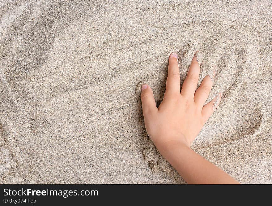 The child is playing with the sea sand. Relax, meditation.