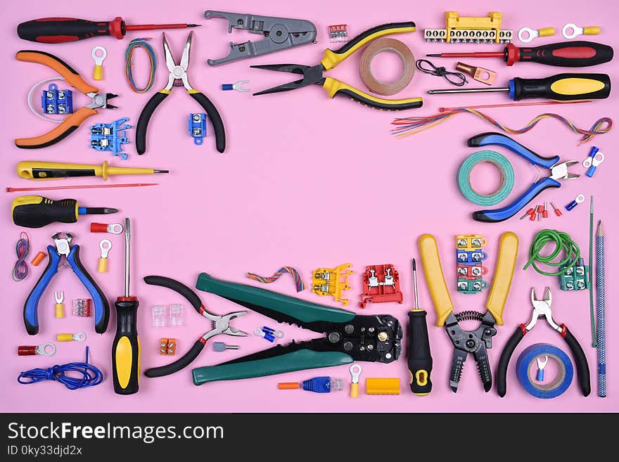 Electrical tools on pink background directly above