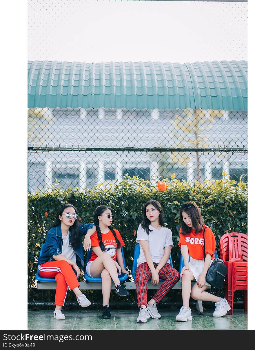 Four Girls Sitting in Gray Steel Bench