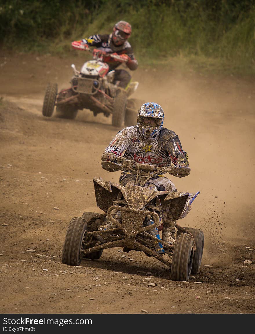 Man Wearing White Racing Outfit Stained With Mud Riding on Stained Mud Atv