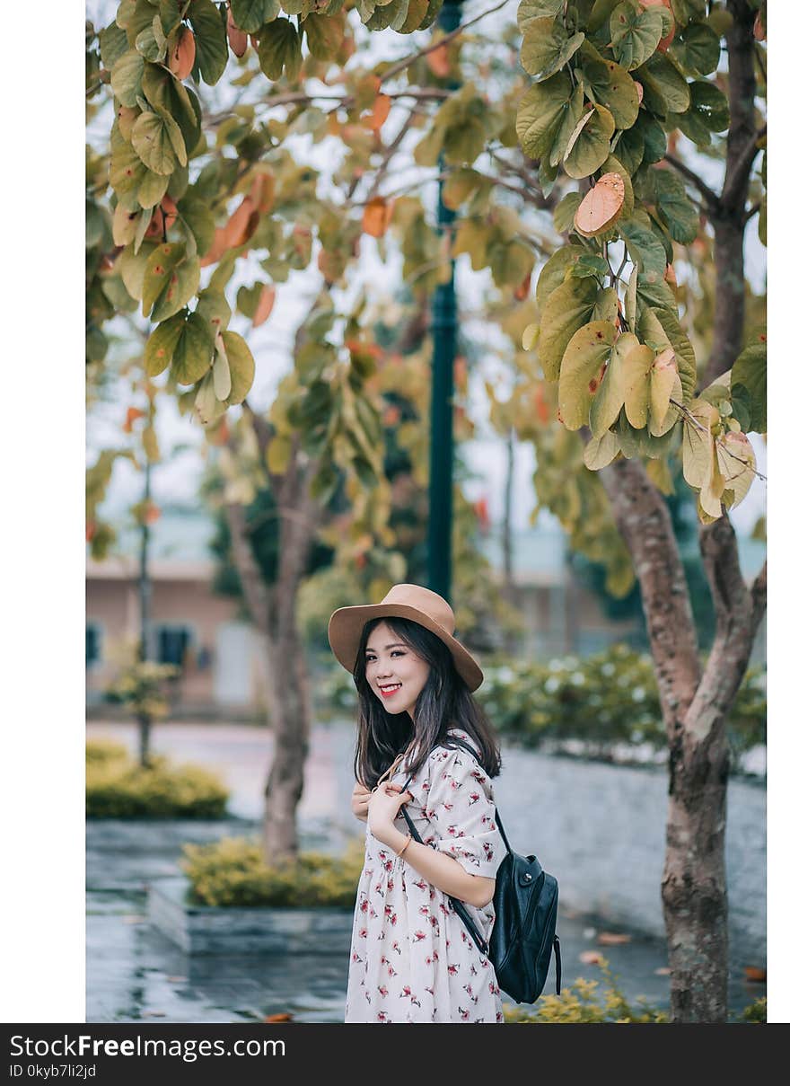 Smiling Woman Wearing Brown Hat and White Floral Elbow-sleeved Dress