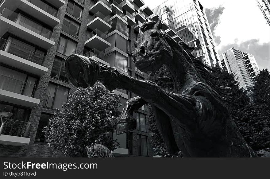 Grayscale Photo of Concrete Horse Statue