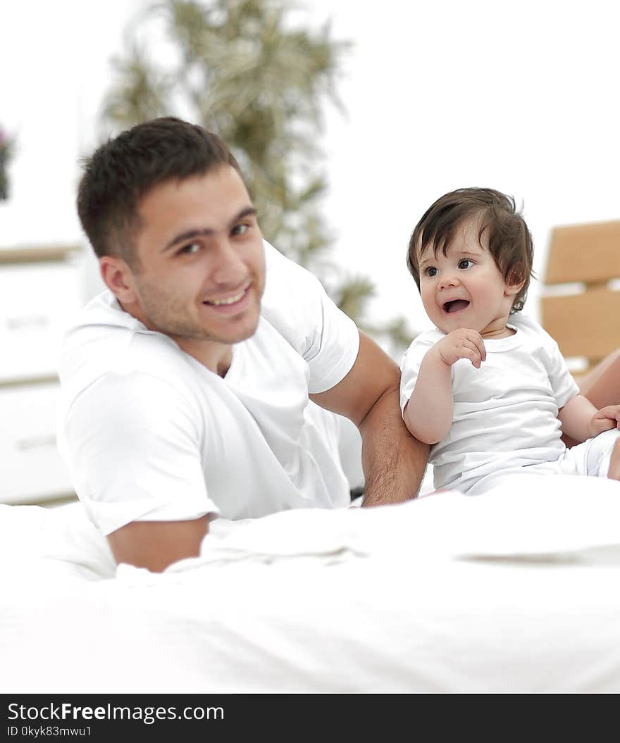 People, family and morning concept - happy child with parents waking up in bed at home. People, family and morning concept - happy child with parents waking up in bed at home