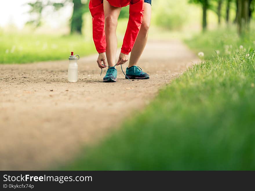 Woman runner tying sport shoes. Walking or running legs, autumn adventure and exercising outdoors. Motivation and inspiration fitness concept outside. Woman runner tying sport shoes. Walking or running legs, autumn adventure and exercising outdoors. Motivation and inspiration fitness concept outside.