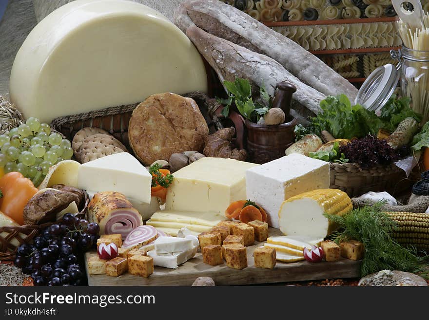 Different types of cheese slices with a cherry tomato on the side