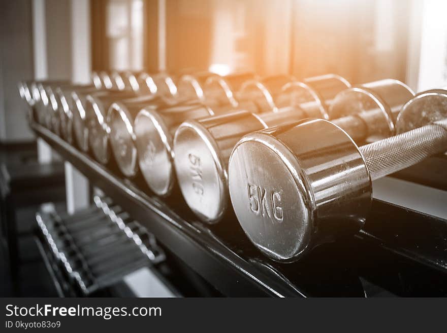 Dumbbells in the gym with monochrome color tone and warm light. Dumbbells in the gym with monochrome color tone and warm light