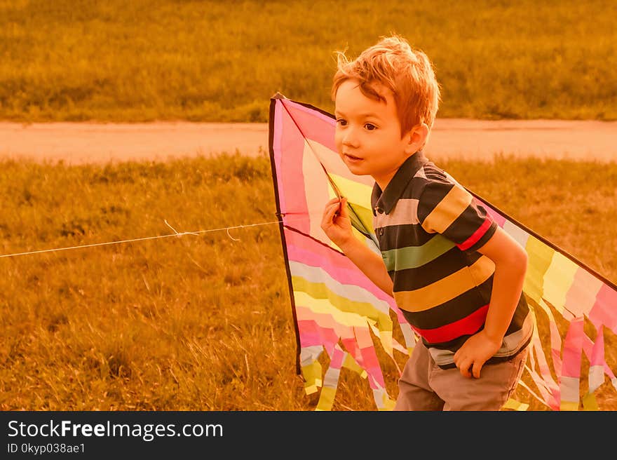 Little Boy Running With Kite In The Field On Summer Day In The Park